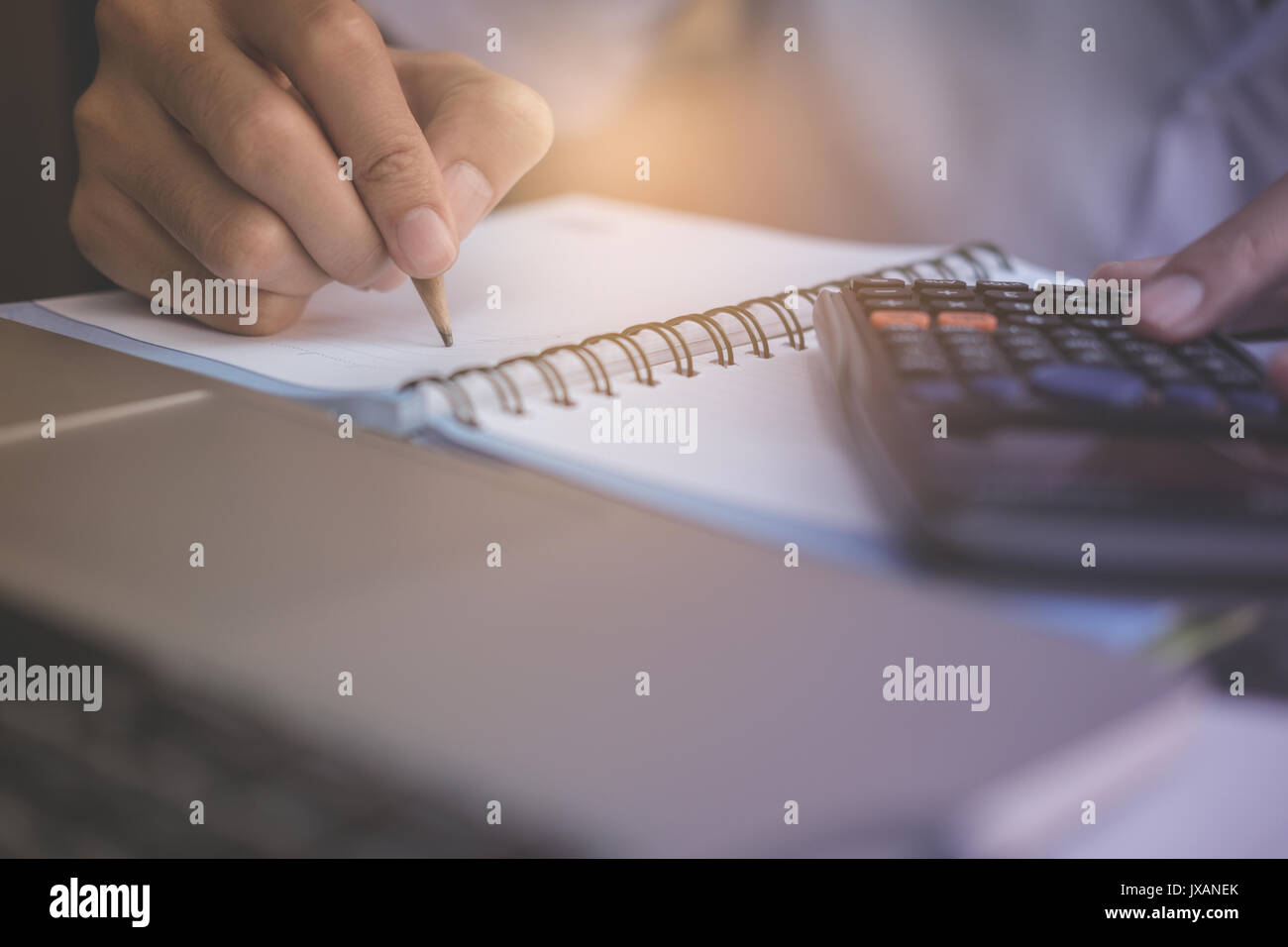 Financial data analyzing hand writing and counting on calculator in office shop cafe with vintage filter Stock Photo