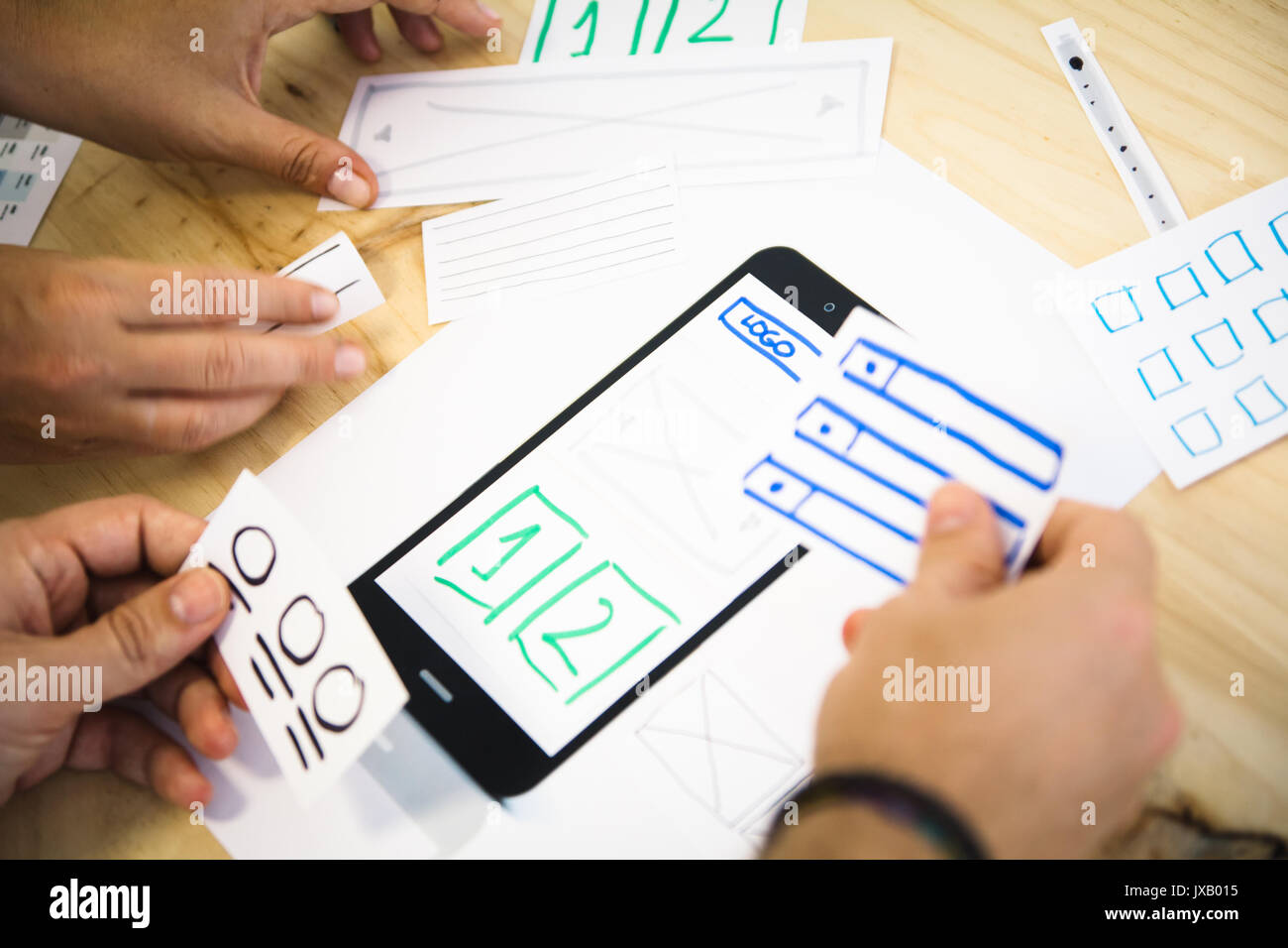 ui designers placing content on smartphone screen Stock Photo