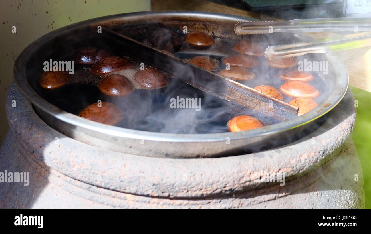 Tea leaf egg, a Chinese or Taiwanese boiled egg delicacy, cooking in a big pot with steam coming out. Stock Photo