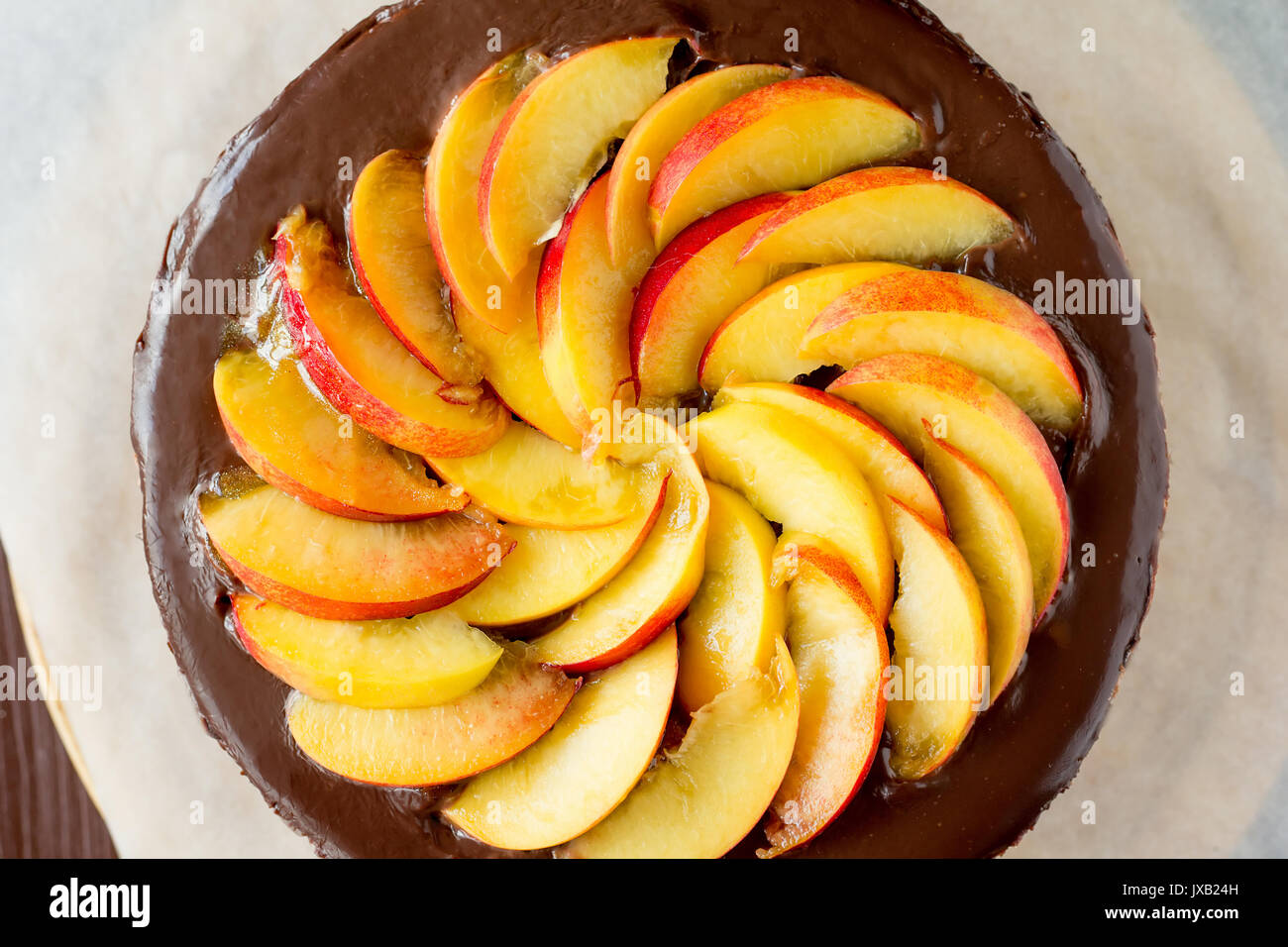 Chocolate cake with nectarines on cooking sheet selective focus top view Stock Photo