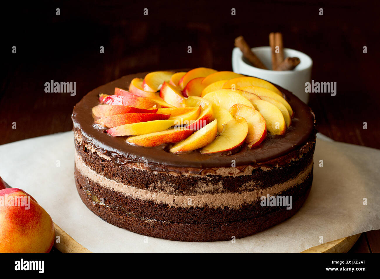 Chocolate cake with nectarines on cooking sheet selective focus Stock Photo