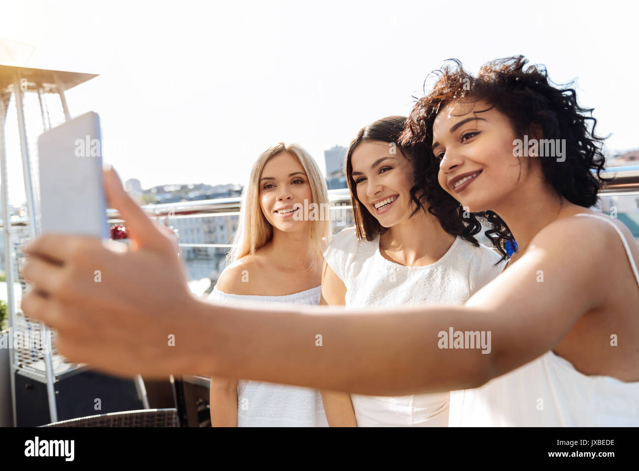 Pleasant brunette woman holding a smartphone Stock Photo