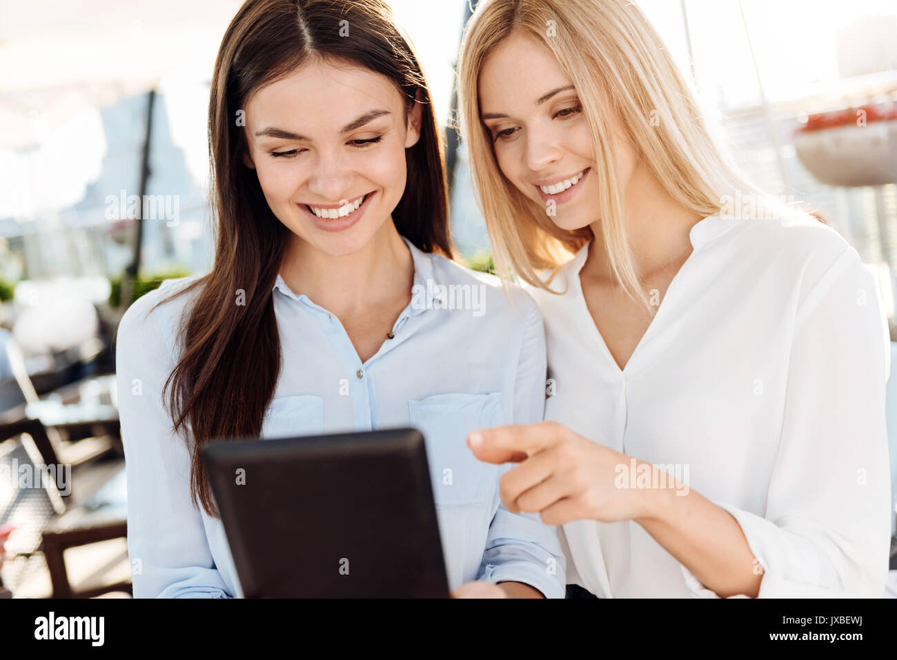 Happy female colleagues using a tablet Stock Photo