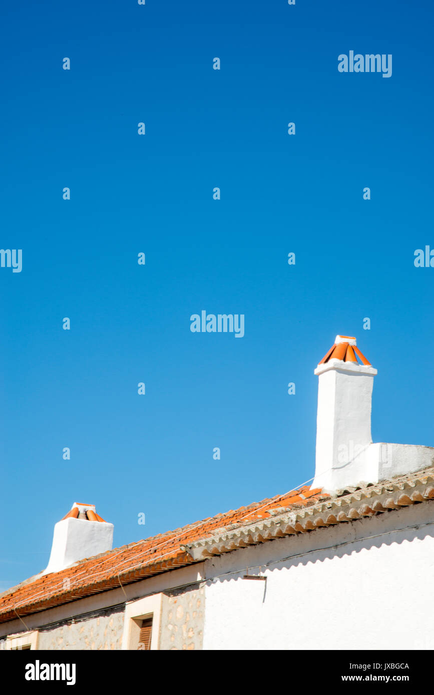 Two chimneys and tiled roofs. Stock Photo