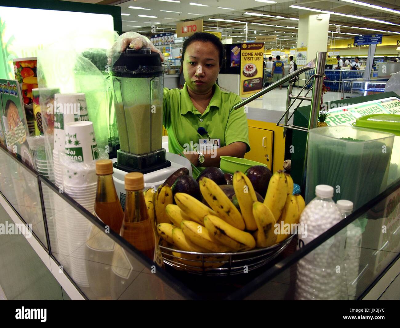 ANGONO, RIZAL, PHILIPPINES - AUGUST 12, 2017: Food kiosk employee prepares a fruit shake for a customer Stock Photo