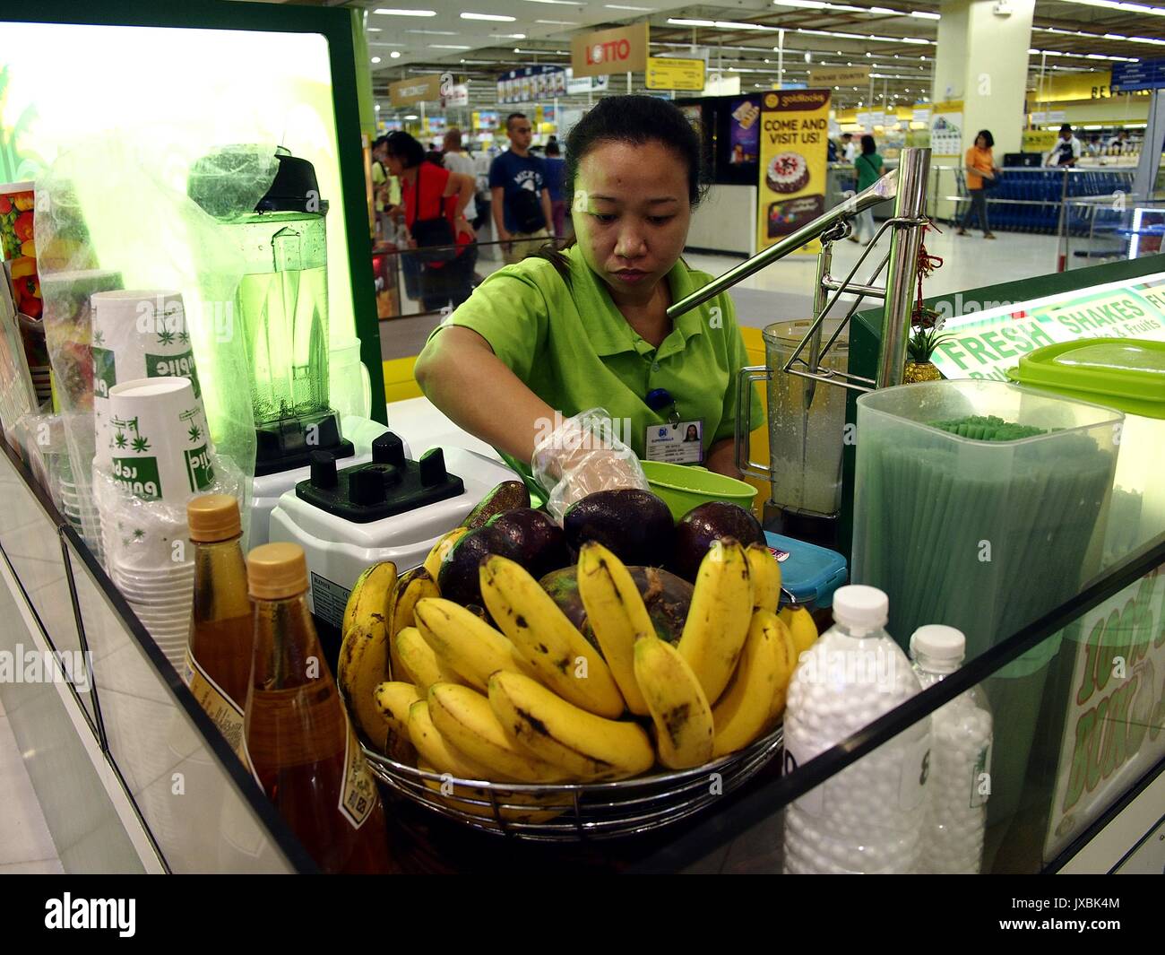 ANGONO, RIZAL, PHILIPPINES - AUGUST 12, 2017: Food kiosk employee prepares a fruit shake for a customer Stock Photo