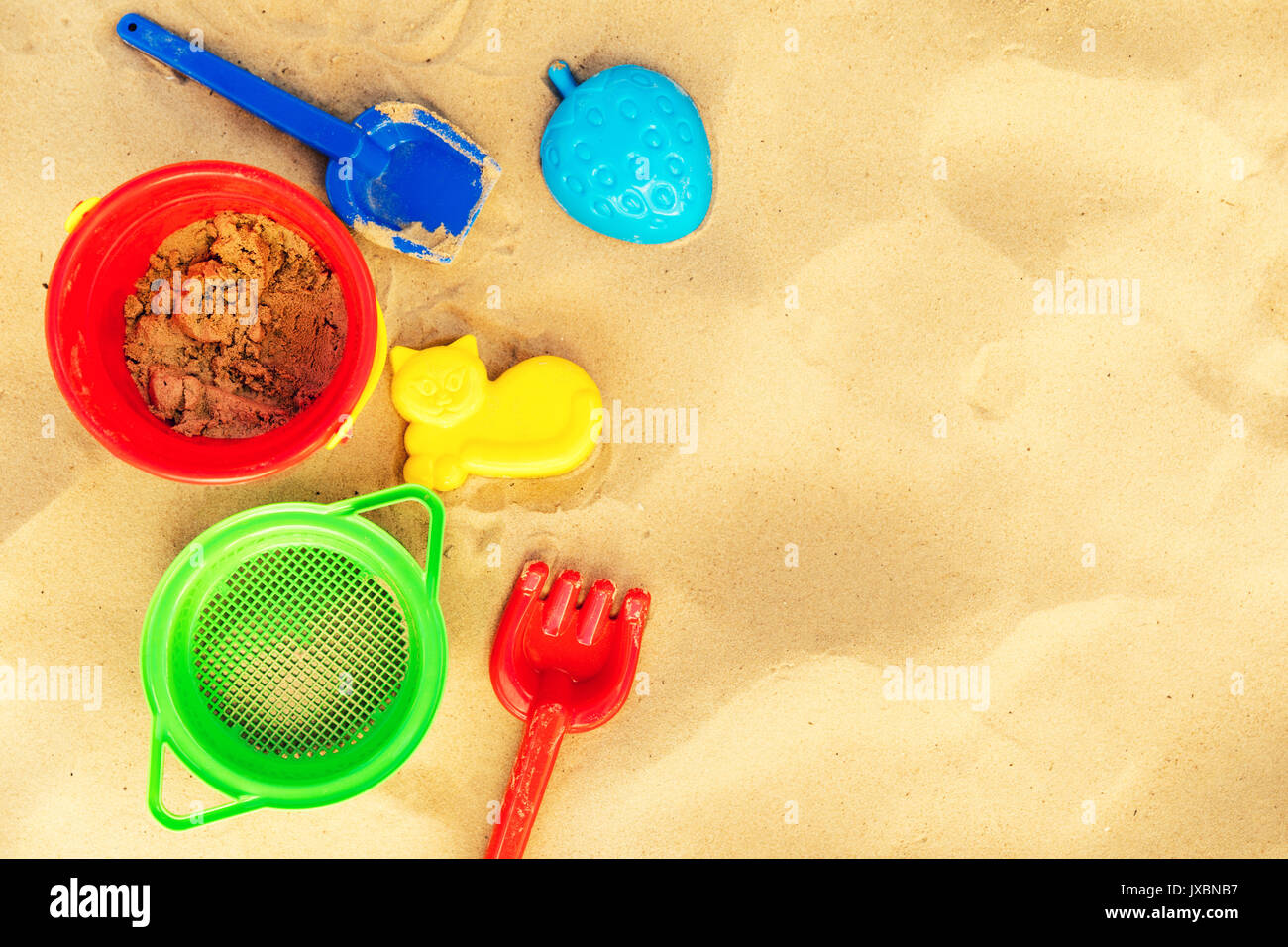 colorful beach toys on sand with copy space Stock Photo