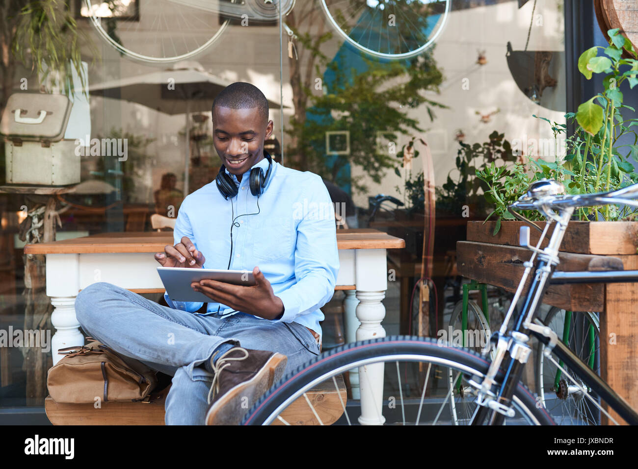 Young man browsing the internet at a sidewalk cafe Stock Photo