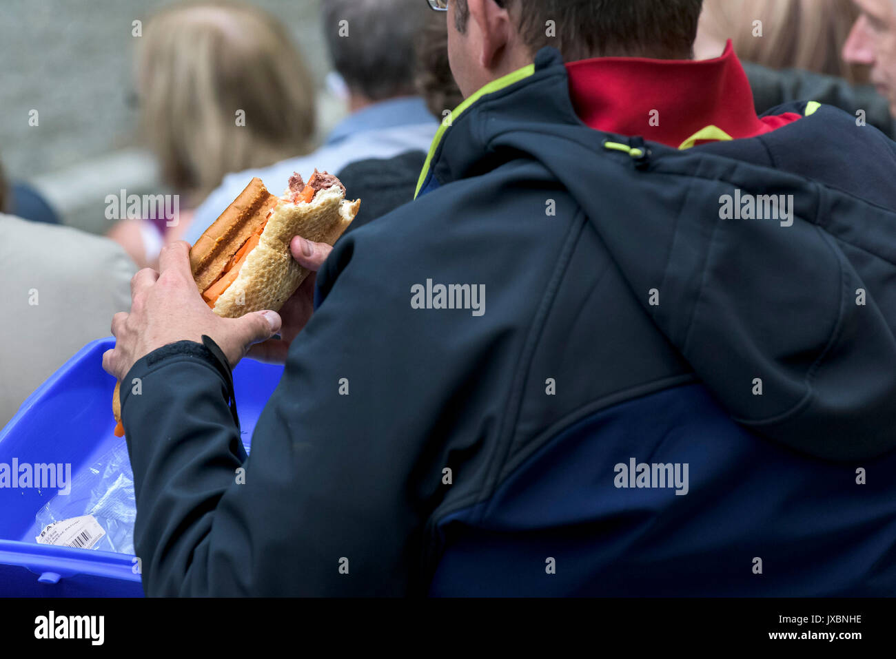 A man eating a large filled baguette. Stock Photo