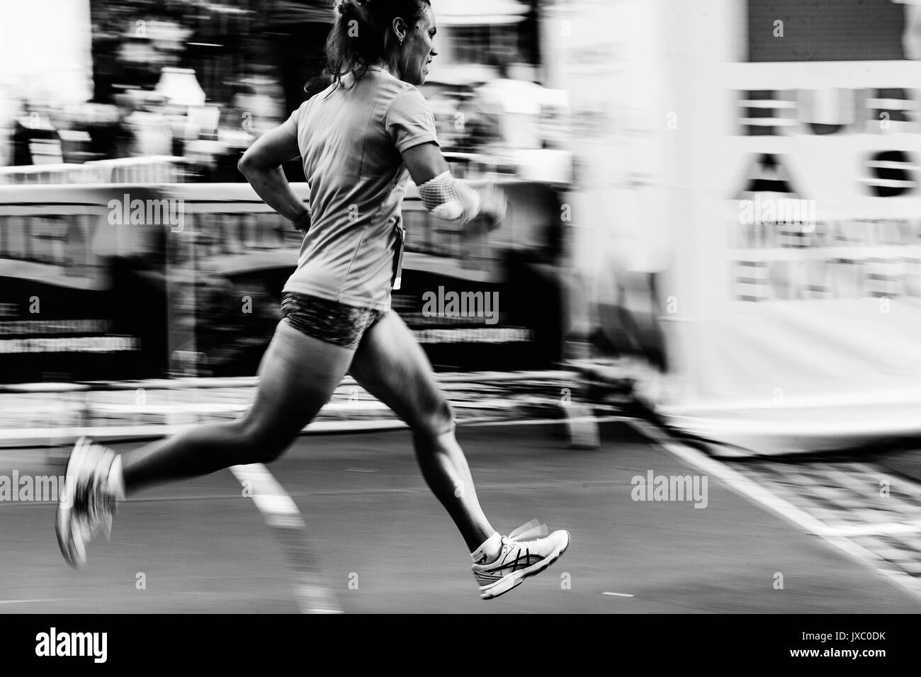 blurred motion of woman runner running on street in Europe-Asia Marathon Stock Photo
