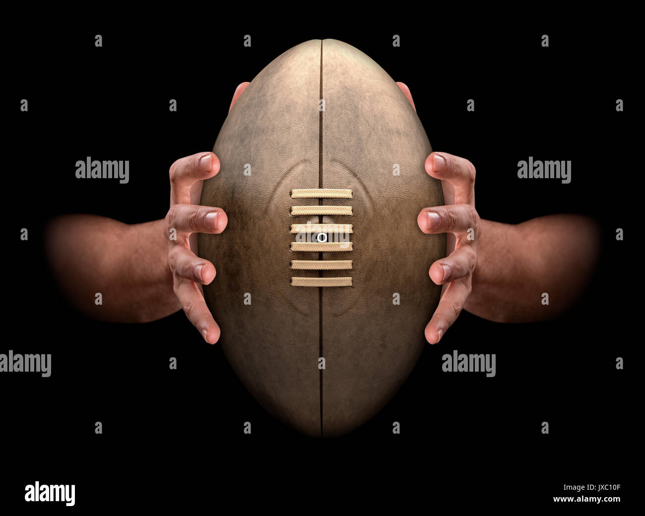 A pair of male hands clamping a vintage rugby ball on an isolated dark background - 3D render Stock Photo