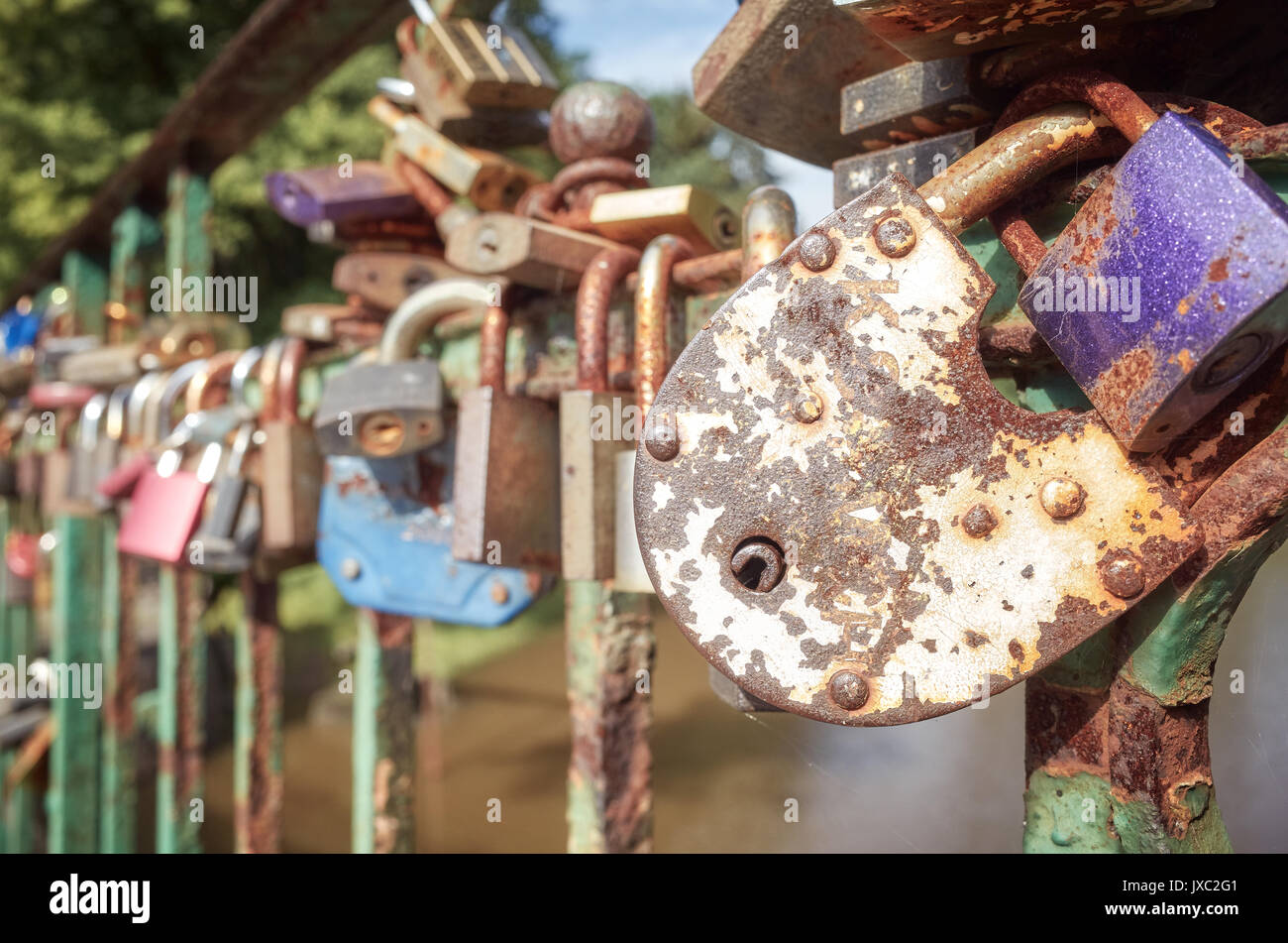 Old rusty padlocks on a bridge, love symbol, shallow depth of field. Stock Photo