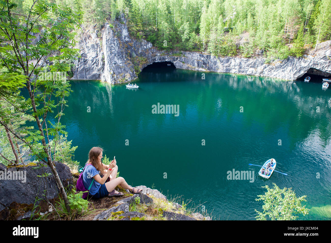 young girl sitting on stone near mountain lake Stock Photo - Alamy