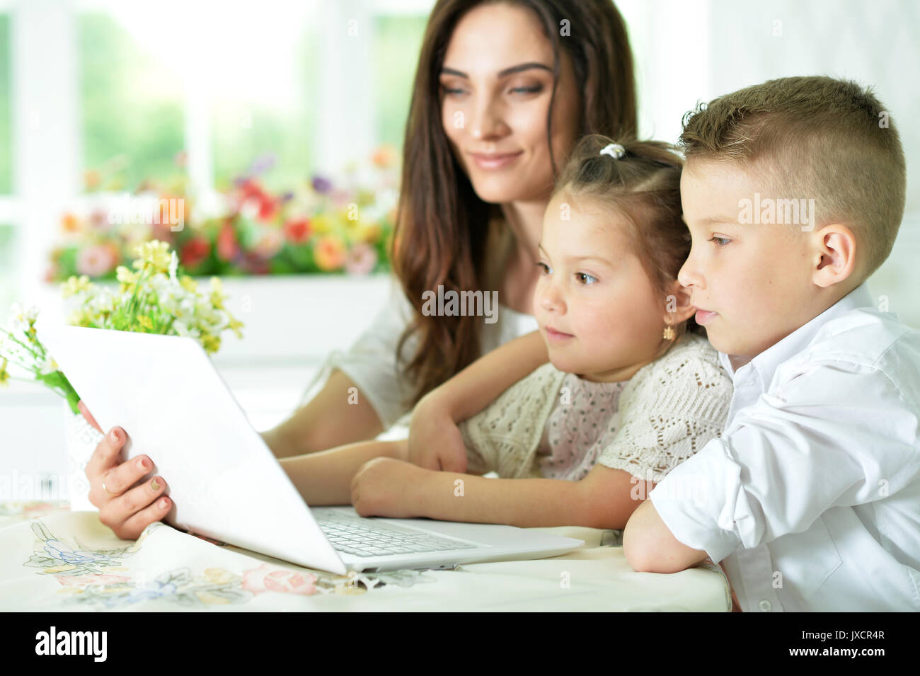 Mother and children with laptop Stock Photo - Alamy