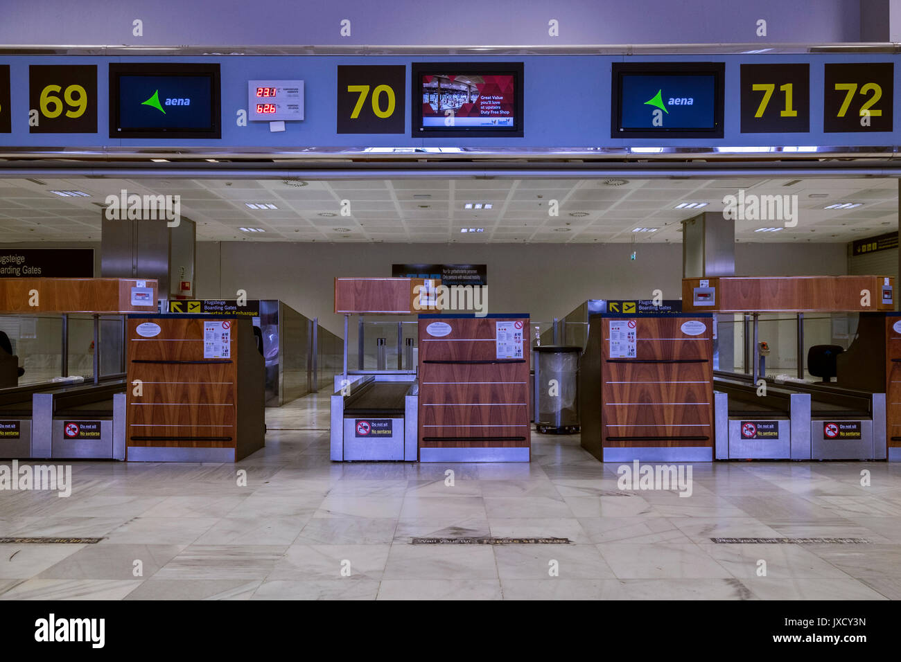 Empty unused check in desks and baggage drop at Tenerife South airport,  departures area, Canary Islands, Spain Stock Photo - Alamy