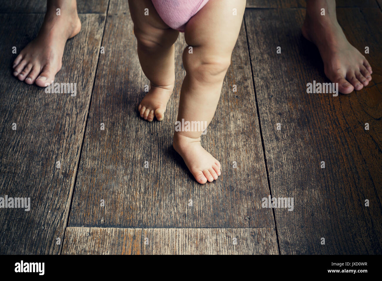 happy baby learning to walk with mother help Stock Photo