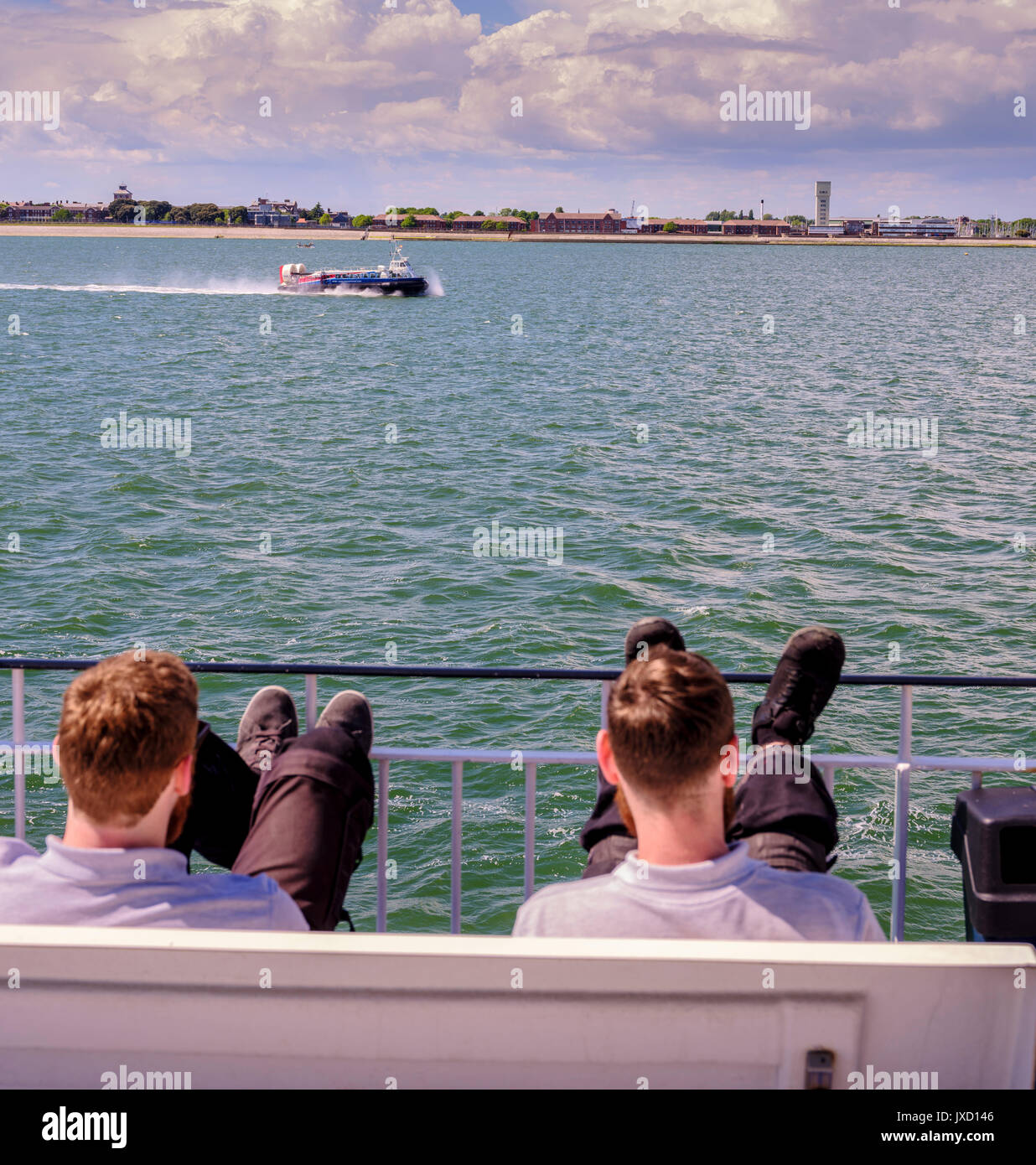 The Portsmouth to Isle of Wight Hovercraft on its crossing between the mainland and the island wathced by passenger on a ferry. Stock Photo