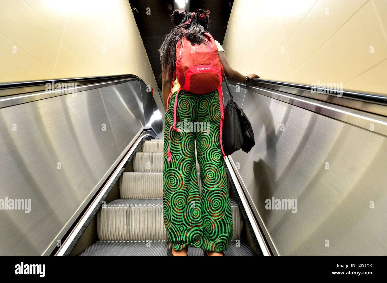 Brussels, Belgium. Woman with green trousers on an escalator in the metro Stock Photo