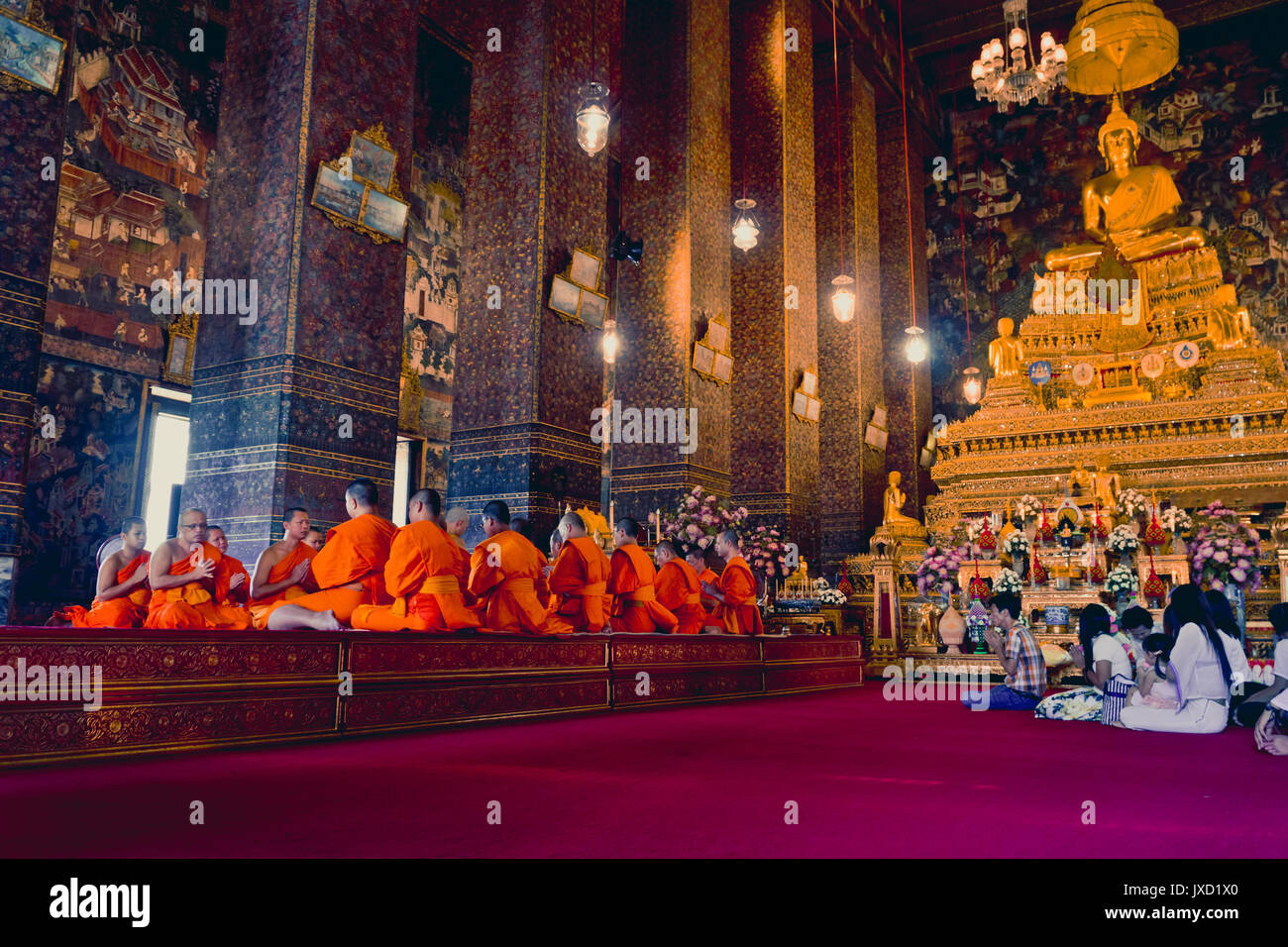 BANGKOK, THAILAND- DECEMBER 26, 2016: Buddhist monks pray at Wat Pho temple in Thailand's capital, Bangkok. Stock Photo