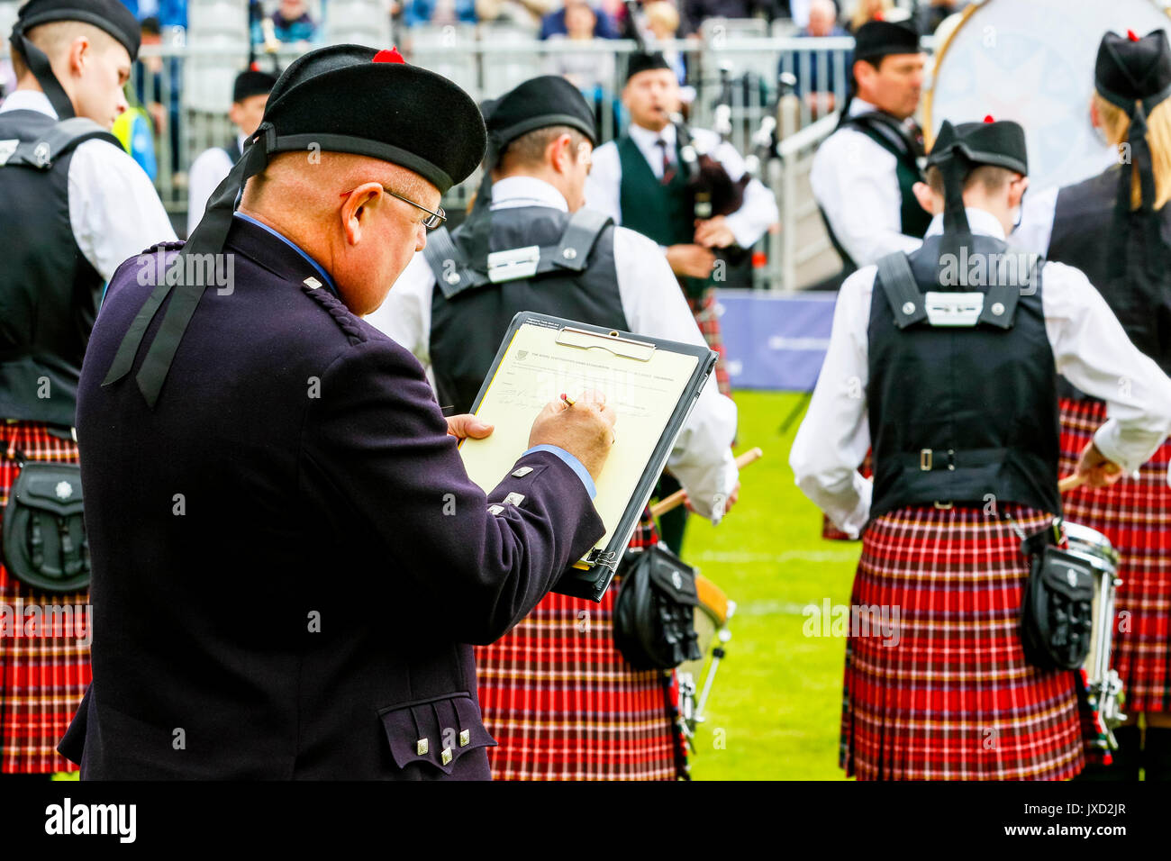 Pipe band adjudicator making up the comments and scores while listening to the band play, Scotland Stock Photo