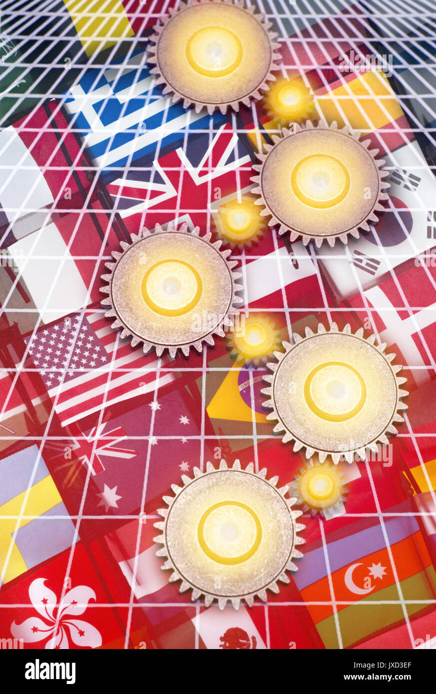 INTERLOCKING COG GEARS ON GRID OVER NATIONAL FLAGS OF MANY NATIONS Stock Photo