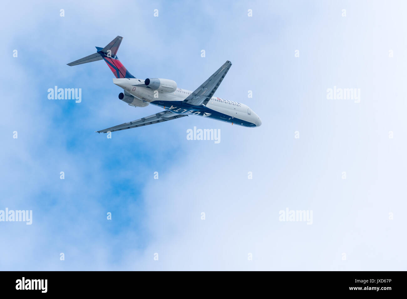 Delta Air Lines passenger jet flying into the clouds. Stock Photo