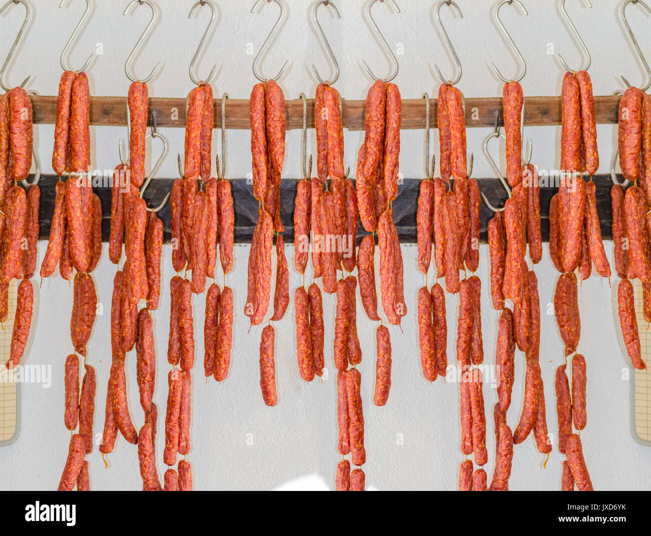 Various smoked sausage or salami in a butcher shop on meat hook Stock