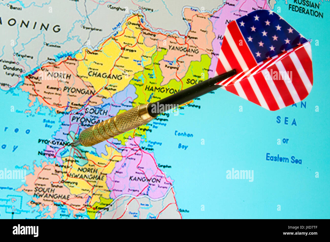 Dart with American flag motif striking Pyongyang on map of North Korea Stock Photo