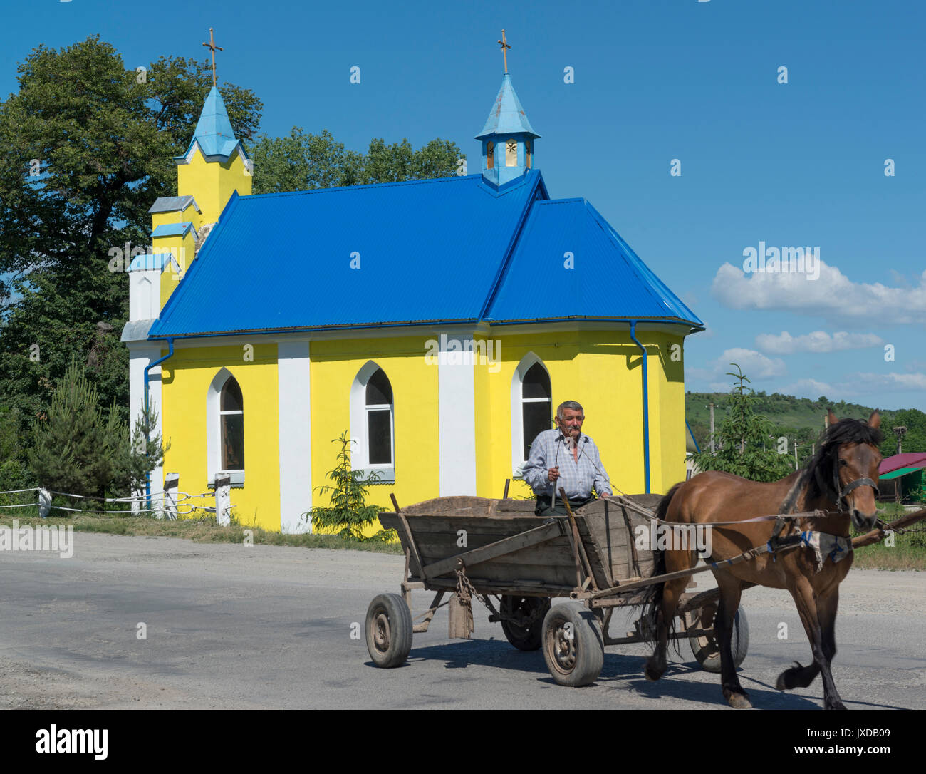 A horse cart passes an orthodox church. Ukraine Stock Photo