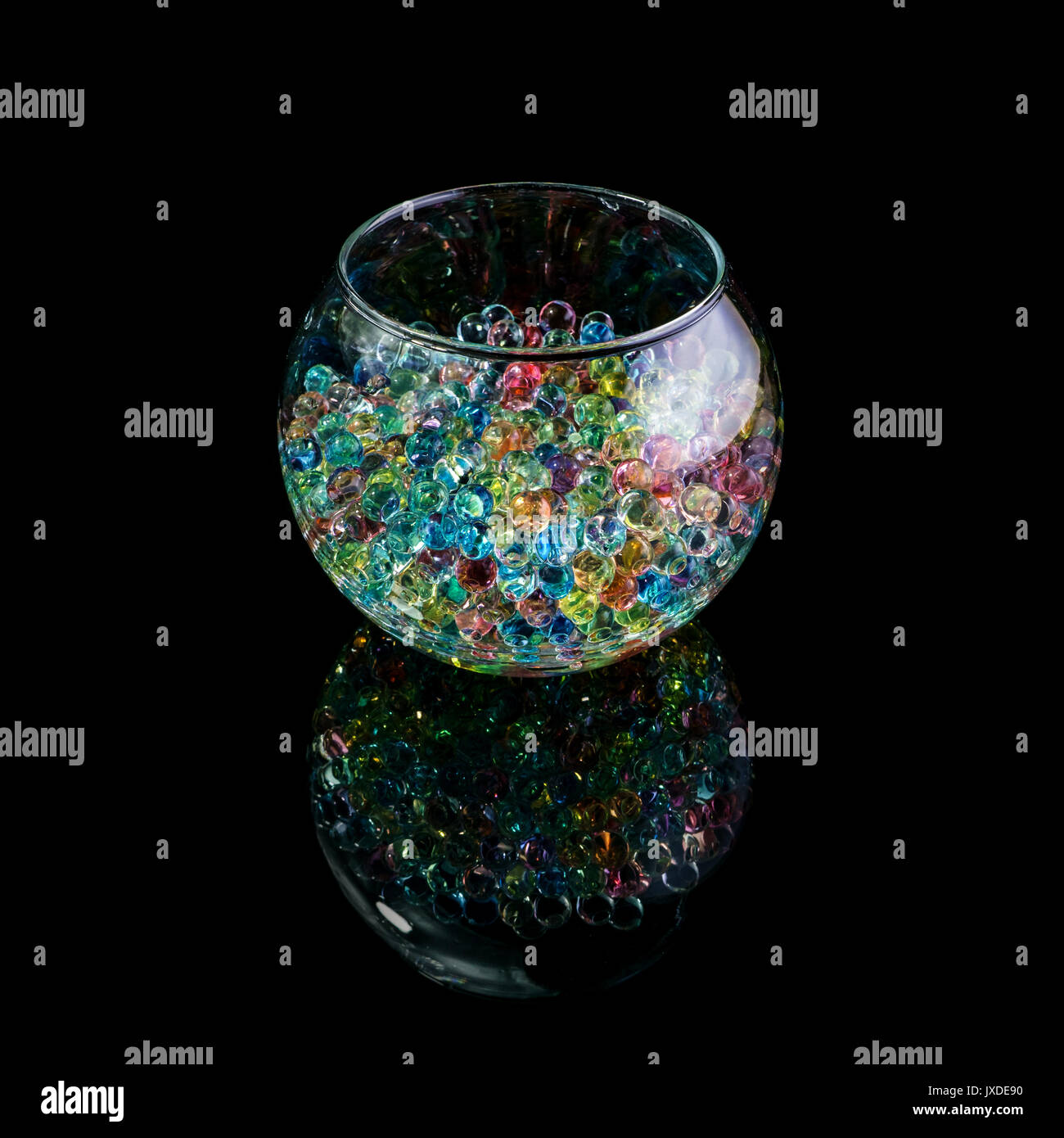 Colored hydrogel balls in a glass vase isolated on a black background Stock Photo