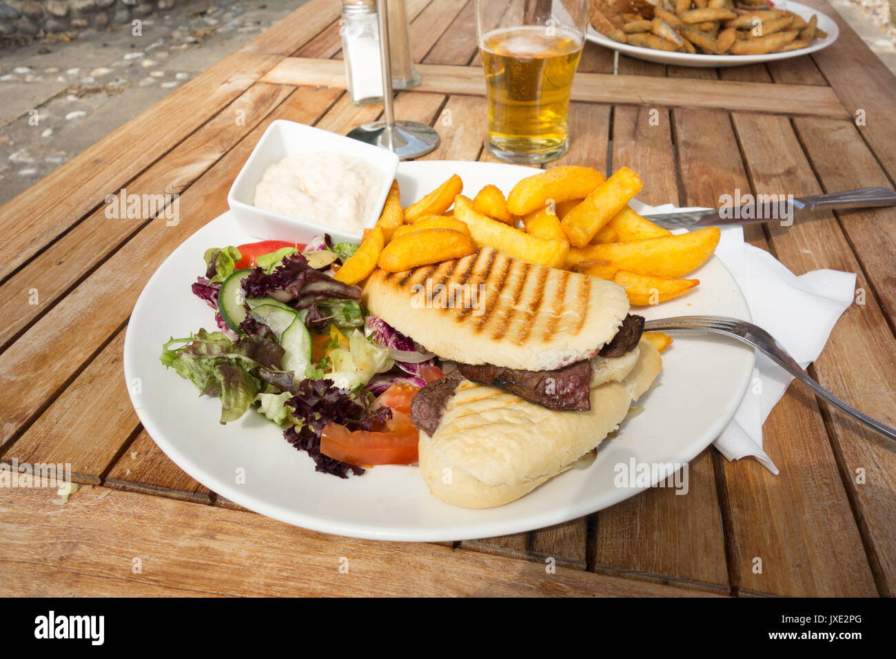 Steak panini meal with chips and side salad Stock Photo