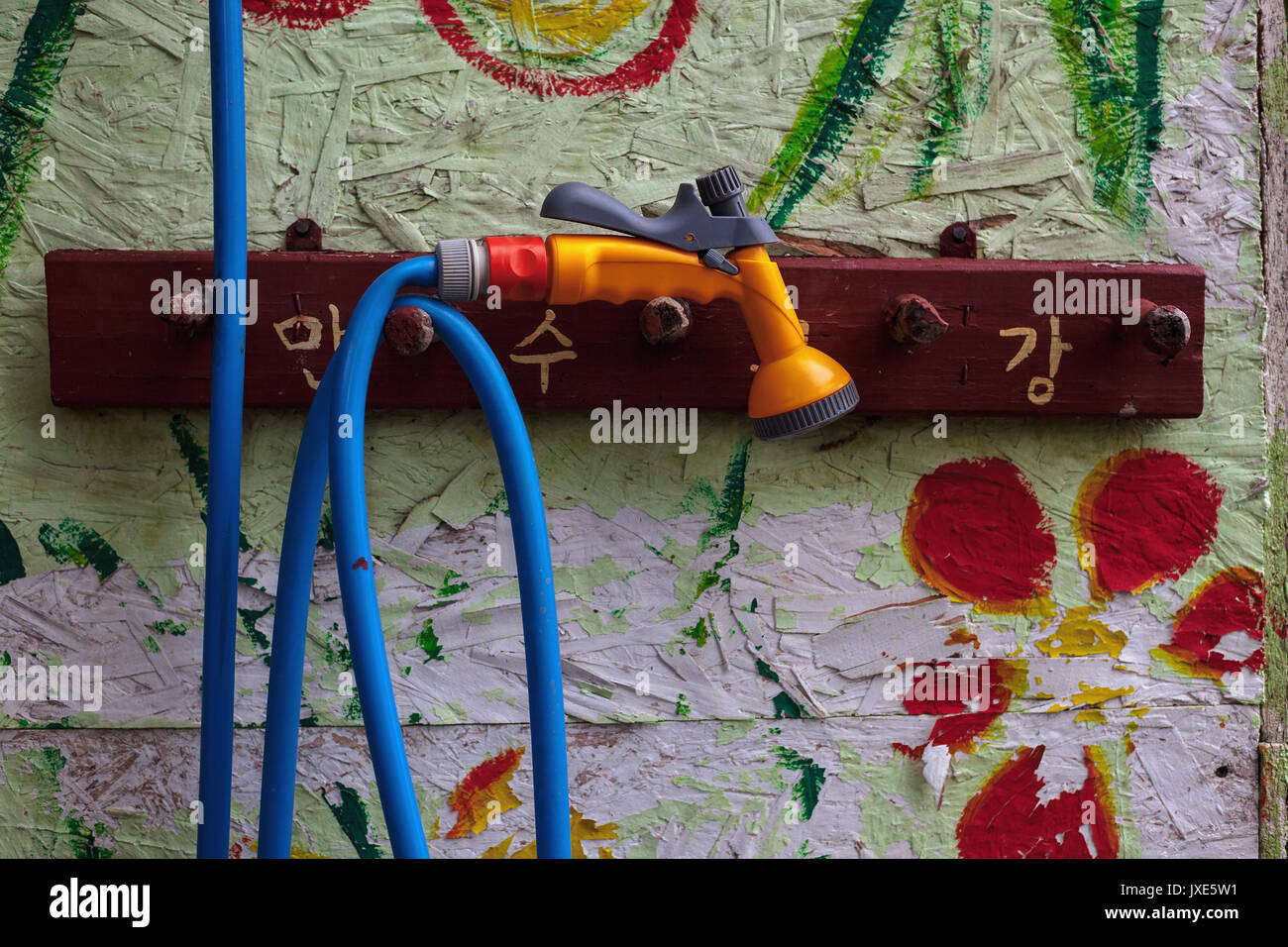 Close-up view on colorful wall and water hose. Stock Photo