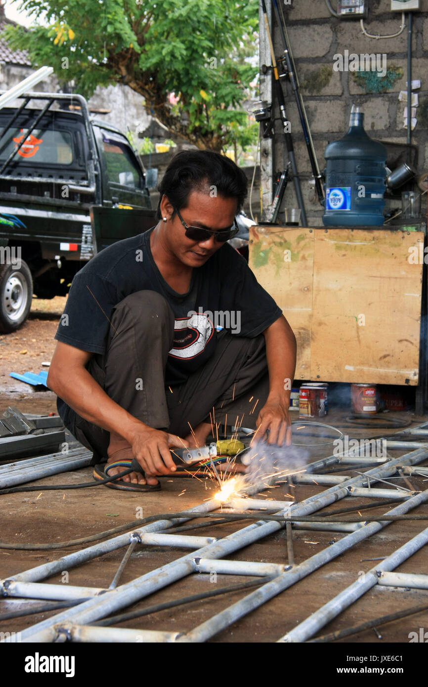 Kuta/Bali - September 13, 2016: Male welder/fabricator welding metalwork in workshop Stock Photo