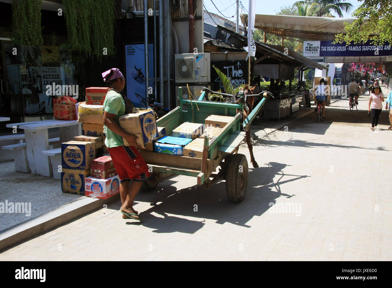 Gili Trawangan, Indonesia - September 9, 2016: Indonesian man loading boxes on to horse and cart in Gili Trawangan Stock Photo