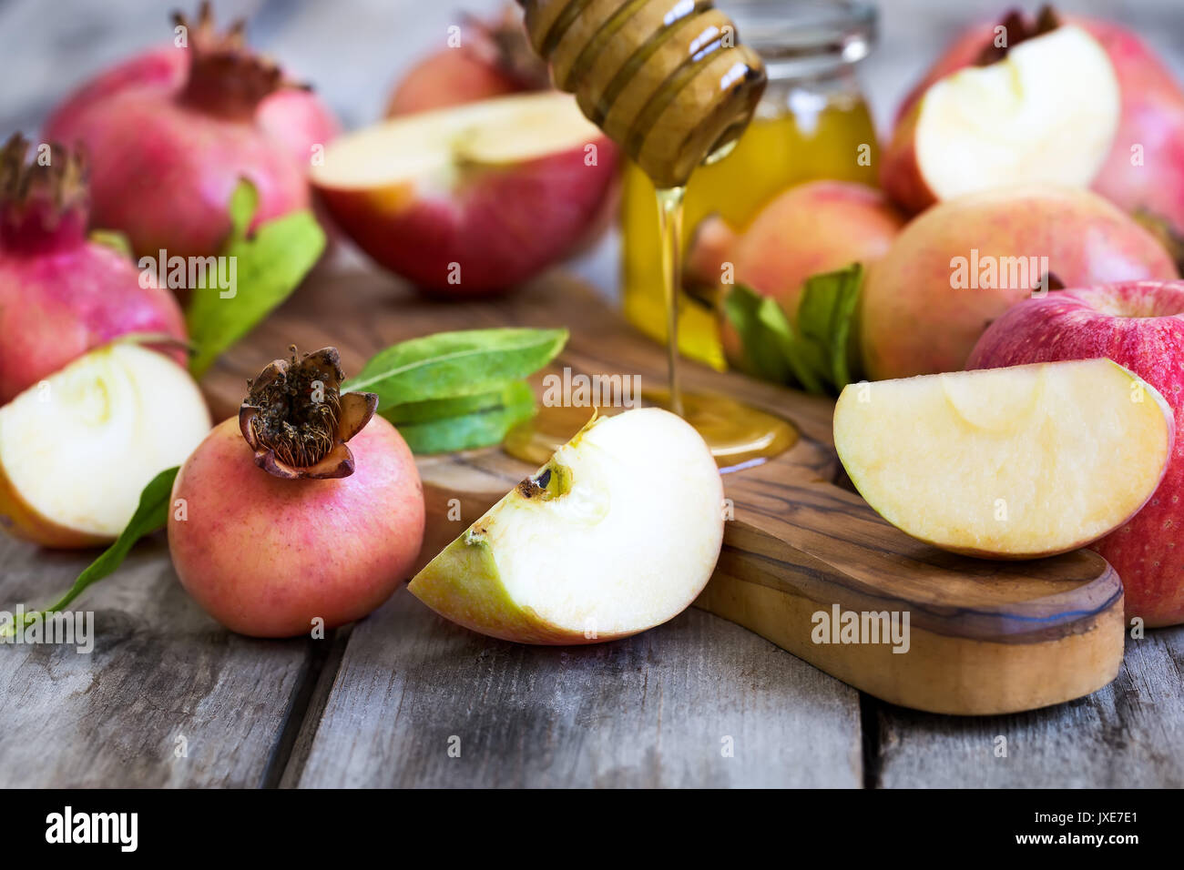 Apples, pomegranate and honey - symbols of judaic holiday Rosh Hashana (Jewish New Year). Selective focus. Stock Photo