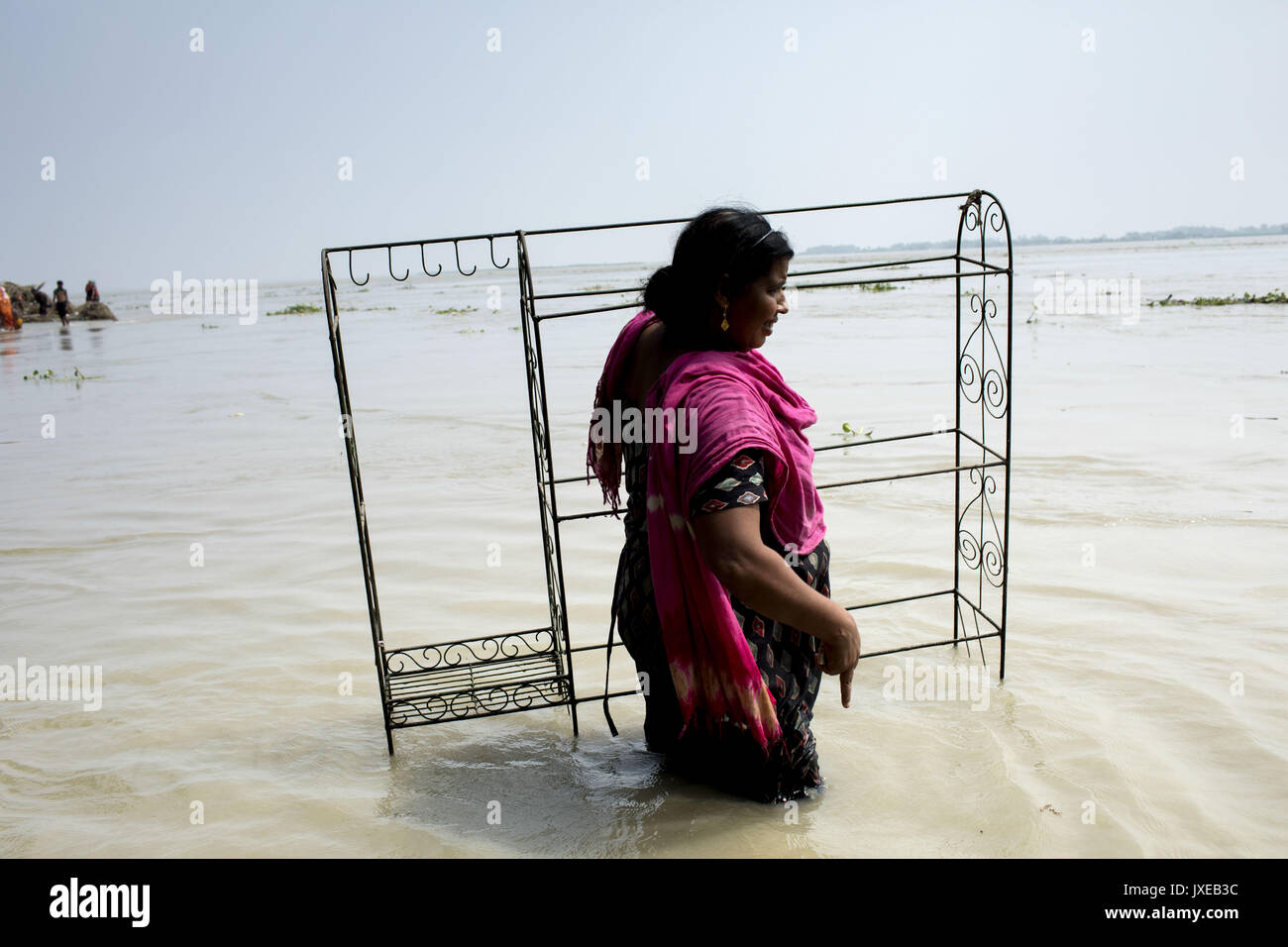 Dhaka, Bangladesh. 15th Aug, 2017. A woman with her belonging move other place when all area under the floodwater at Sariakandhi, Bogra. Flood-related incidents in Dinajpur, Gaibandha and Lalmonirhat raising the death toll to 30 in the last three days across the country. Credit: K M Asad/ZUMA Wire/Alamy Live News Stock Photo