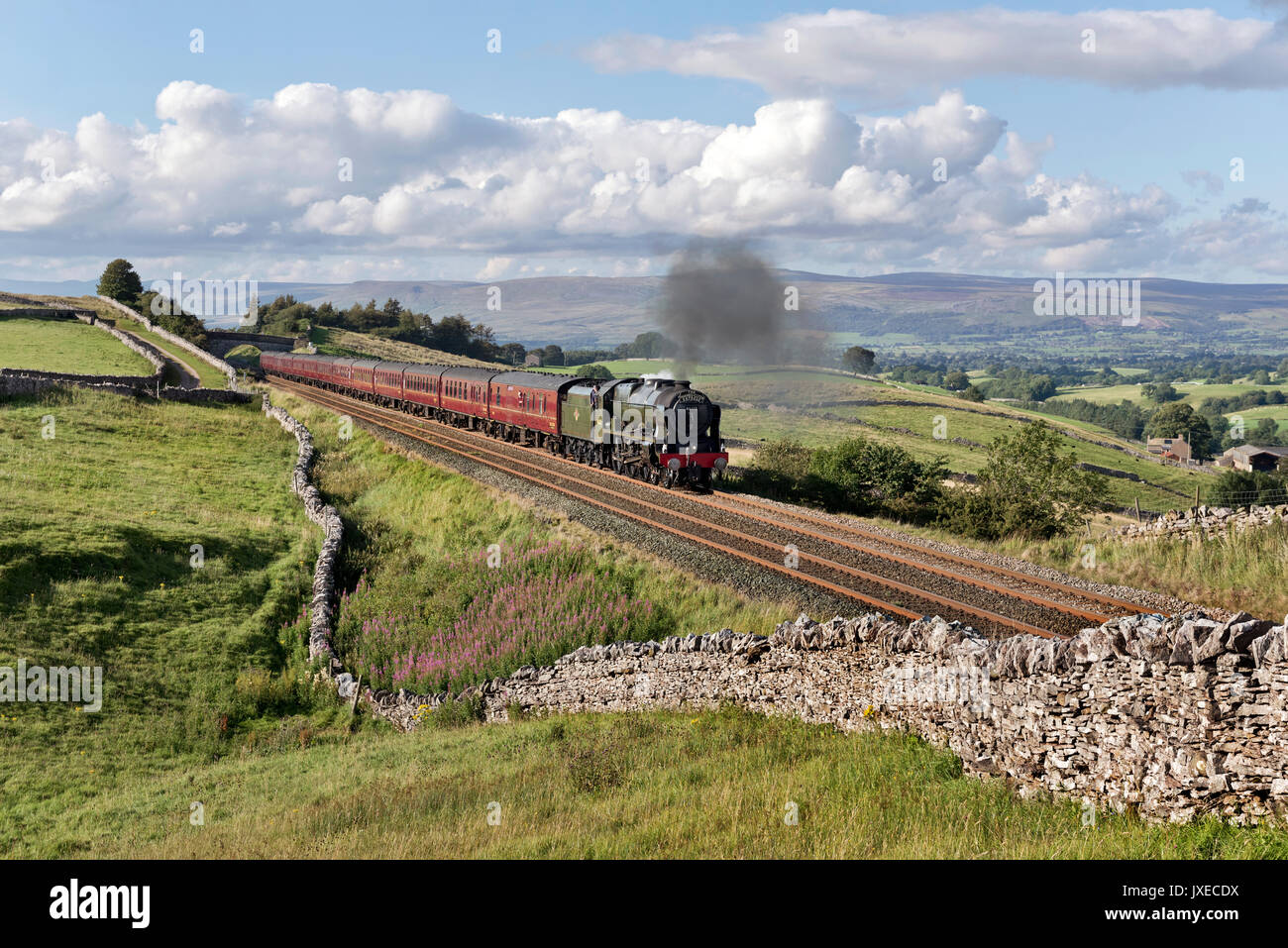 Kirkby Stephen, Cumbria, UK, 15th August 2017. Steam locomotive Scots Guardsman hauls 'The Dalesman' Summer special back from Carlisle on the Settle-Carlisle railway line, seen here at Birkett Common near Kirkby Stephen, Cumbria. Scots Guardsman is due for an overhaul and may not be seen again on the railway network for some time. Significantly the locomotive is seen with a 'Thames-Clyde Express' headboard, which was the name of one of the express train services that ran over this railway line back in the days of steam. Credit: John Bentley/Alamy Live News Stock Photo