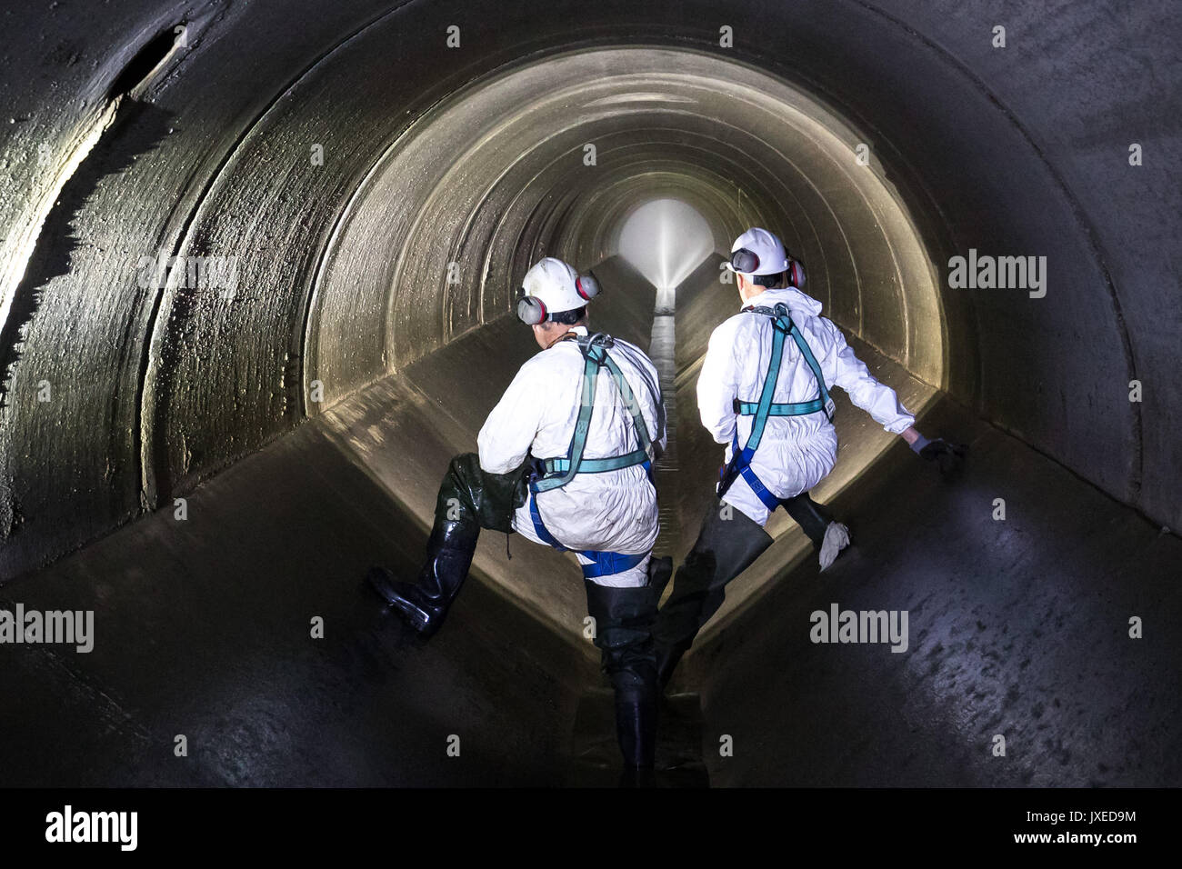 Schweinfurt, Germany. 17th July, 2017. Sewage workers can be seen in the underground sewage during an inspeaction walk in Schweinfurt, Germany, 17 July 2017. A high-pressure cleaner is placed in the centre. Unnoticed by many people sewage workers take care that cities do not turn into stinking cesspools. A great amount of the daytime they, therefore, spend in the underground. Photo: Daniel Karmann/dpa/Alamy Live News Stock Photo