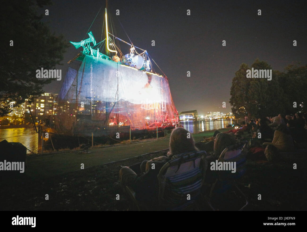 Vancouver. 15th Aug, 2017. People watch the tall ship multi-media acrobatic show 'Nomadic Tempest' presented by Caravan Stage Company on a 100-ft-long vessel of a tall ship from the shore in Vancouver, Canada. Aug. 15, 2017. Credit: Liang Sen/Xinhua/Alamy Live News Stock Photo