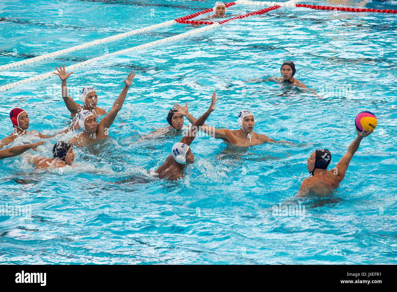 Kuala Lumpur, Malaysia. 16th Aug, 2017.  Koh Jian Ying (number 12) of Singapore, attempts to score against Thailand in the men's water polo round robin match during the South East Asian Games in Kuala Lumpur. Singapore won 13-2 in their first match of the competition. Singapore dominates the competition, having won all 26 editions since the beginning of the South East Asian Peninsular Games in 1965. Credit: SOPA Images Limited/Alamy Live News Stock Photo