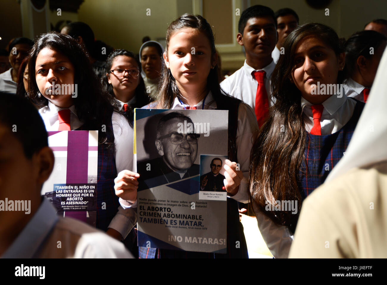 A young believer holds a picture of bishop Oscar Romero during Mass in the cathedral of San Salvador in El Salvador, 15 August 2017. Thousands of believers in the Central American city commemorated the beatified bishop, 100 years after Romero's birth. Photo: Vladimir Chicas/dpa Stock Photo