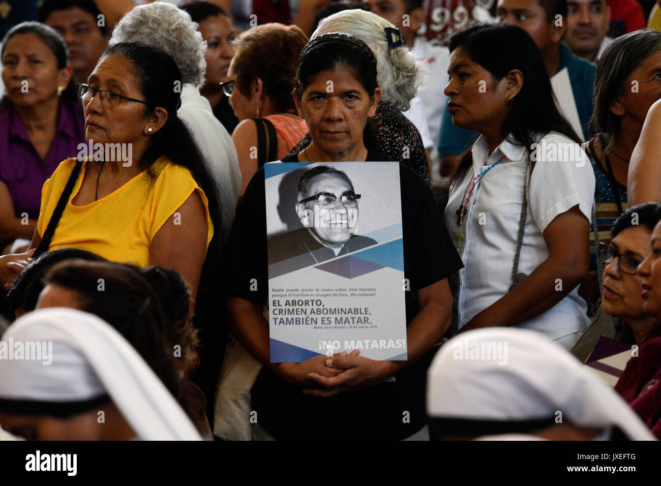 A believer holds a picture of bishop Oscar Romero during Mass in the cathedral of San Salvador in El Salvador, 15 August 2017. Thousands of believers in the Central American city commemorated the beatified bishop, 100 years after Romero's birth. Photo: Vladimir Chicas/dpa Stock Photo