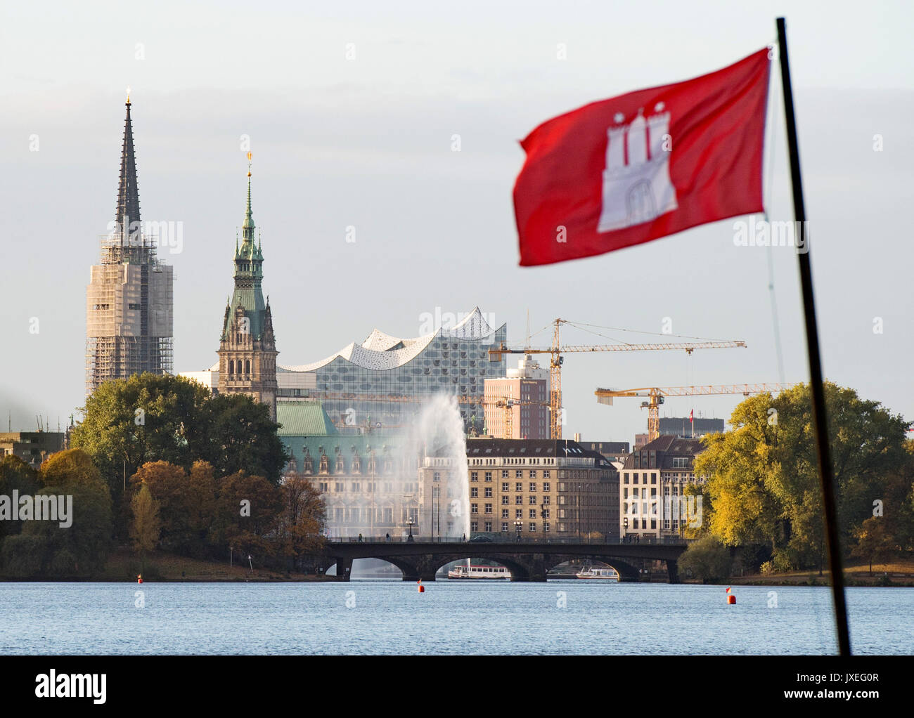FILE - A file picture dated 29 October 2016 shows a Hamburg flag by the Outer Alster lake with the town hall, the Elbe Philharmonic Hall and the Alster fountain in the background, in Hamburg, Germany. Hamburg is the most livable city in Germany, according to an annual ranking by "The Economist" Photo: Daniel Reinhardt/dpa Stock Photo