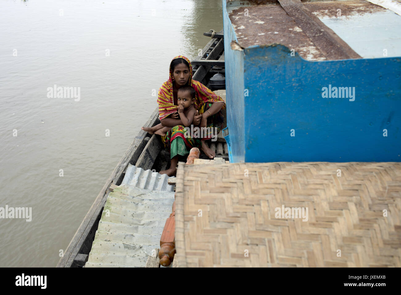 Dhaka, Bangladesh. 16th Aug, 2017. Morjina with her family member come with their belonging to safe place for continuous flooding in Kajla area at Bogra. Peoples' suffering continues as many of them left their homes along with their cattle, goats, hens and other pets and took shelter in safe areas and many of these people have still not been able to return as water has not fully receded from their homes. Flood-related incidents in Dinajpur, Gaibandha and Lalmonirhat raising the death toll to 30 in the last three days across the country. (Credit I Stock Photo