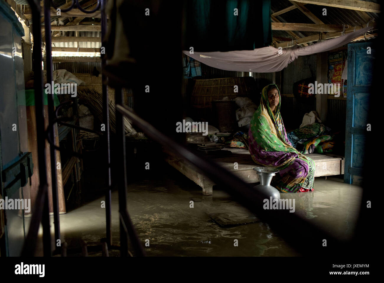 Dhaka, Bangladesh. 16th Aug, 2017. Jahanara sit in her home that is full of floodwater in Manikdi area at Bogra. Peoples' suffering continues as many of them left their homes along with their cattle, goats, hens and other pets and took shelter in safe areas and many of these people have still not been able to return as water has not fully receded from their homes. Flood-related incidents in Dinajpur, Gaibandha and Lalmonirhat raising the death toll to 30 in the last three days across the country. Credit: K M Asad/ZUMA Wire/Alamy Live News Stock Photo