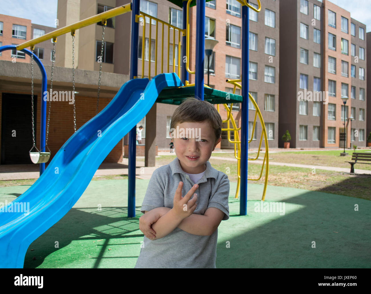 Small child on slide in an outdoors playground. Stock Photo