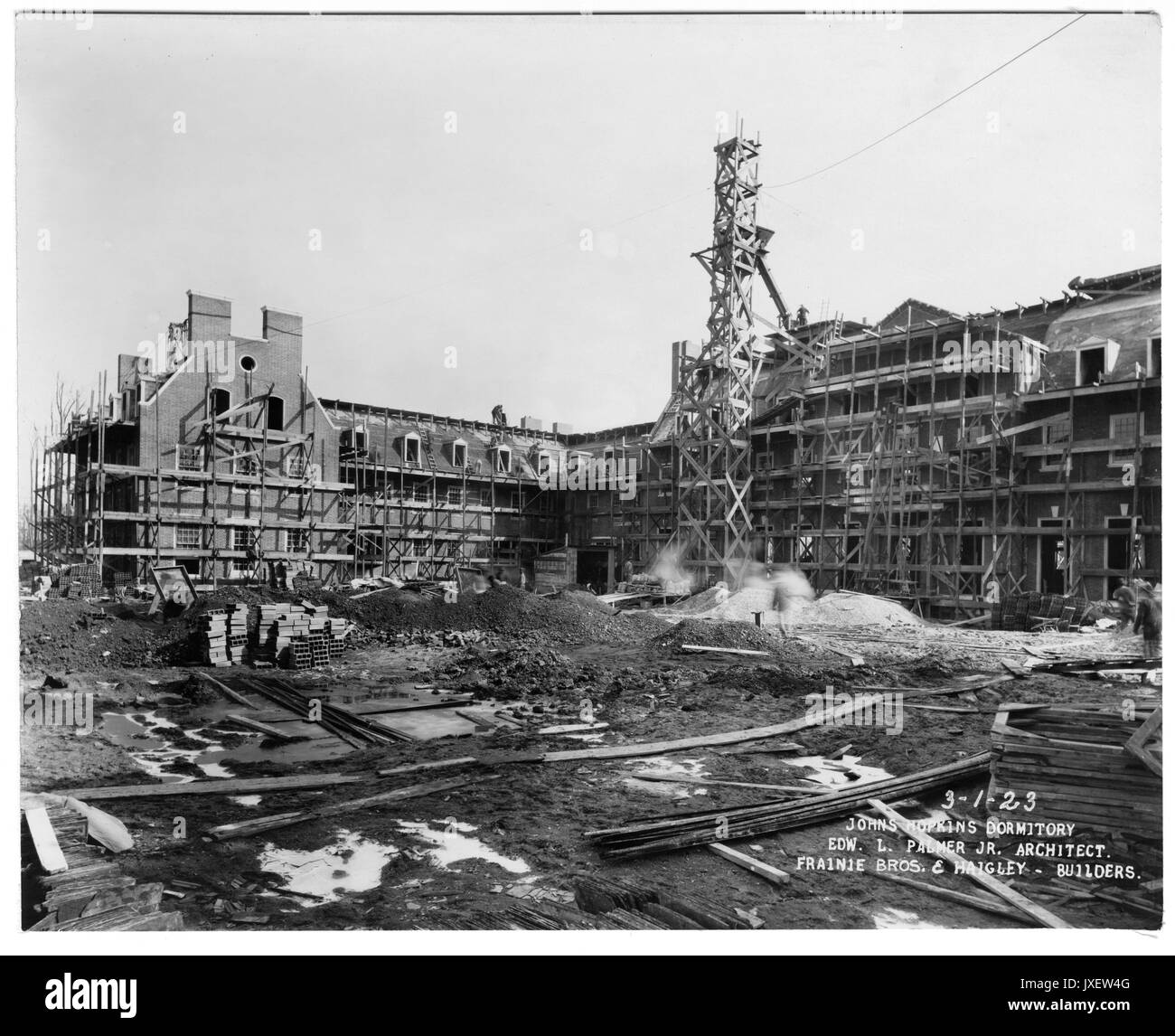 Alumni Memorial Residences AMR and courtyard under construction, Scaffolding around building, Men working on the rooftops, as well as on the ground, A lot of construction material piled in the courtyard area, 1923. Stock Photo