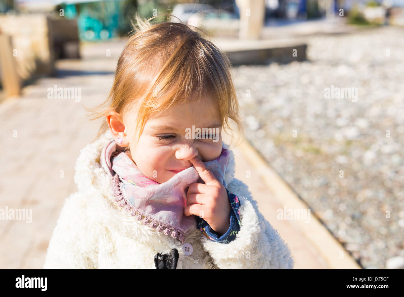 Cute little toddler baby girl picking her nose. Stock Photo