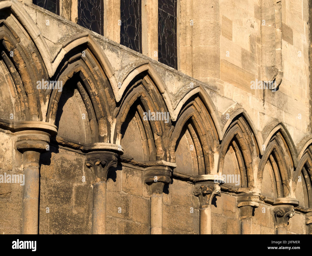 Row of old, stone pointed Gothic arches decorating exterior wall of All Saints Church, Stamford, England, UK Stock Photo