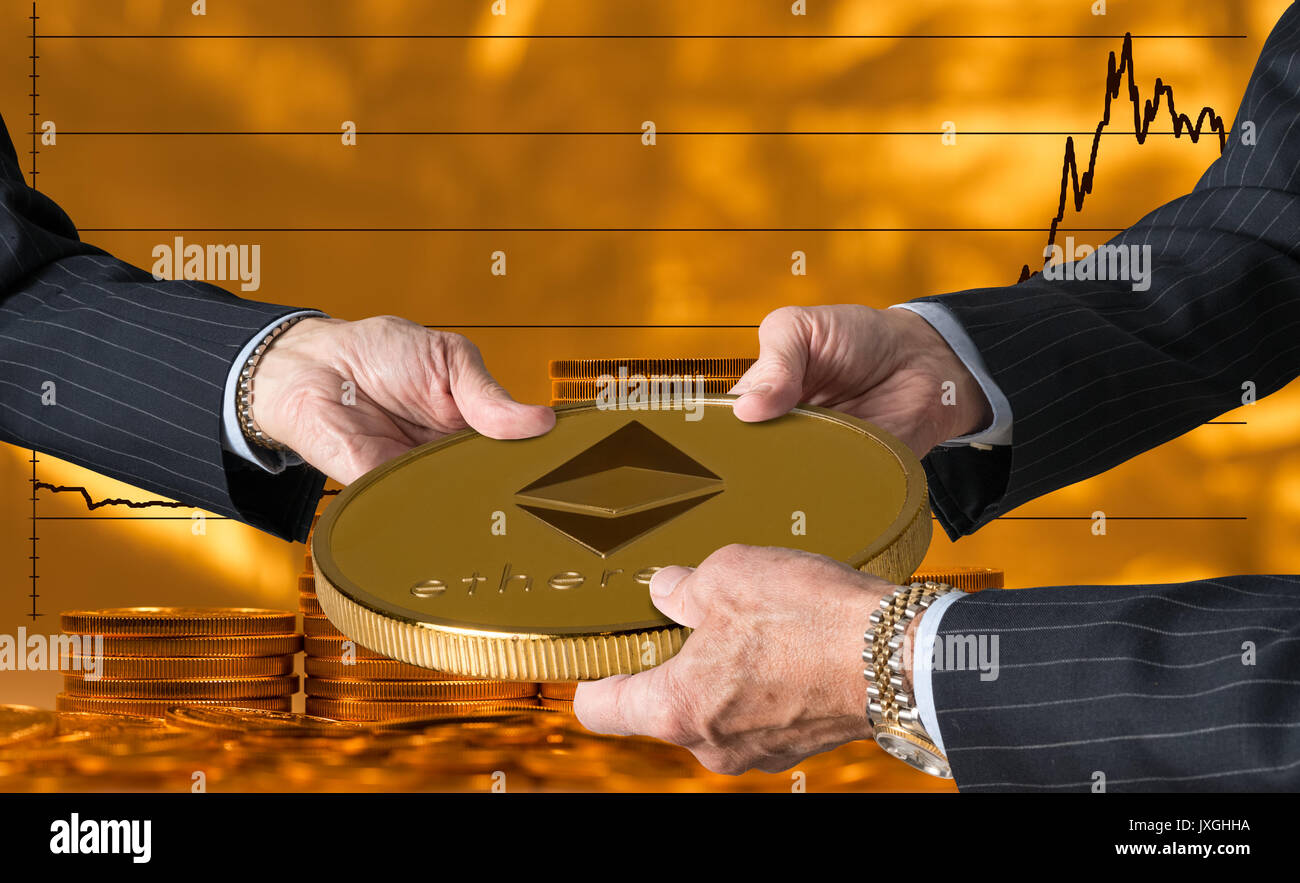 Three traders hands holding large ether or ethereum coin Stock Photo